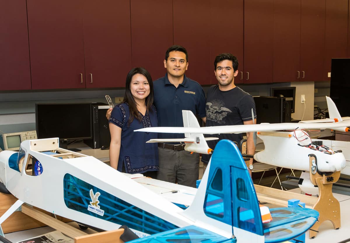 Students stand with model plane