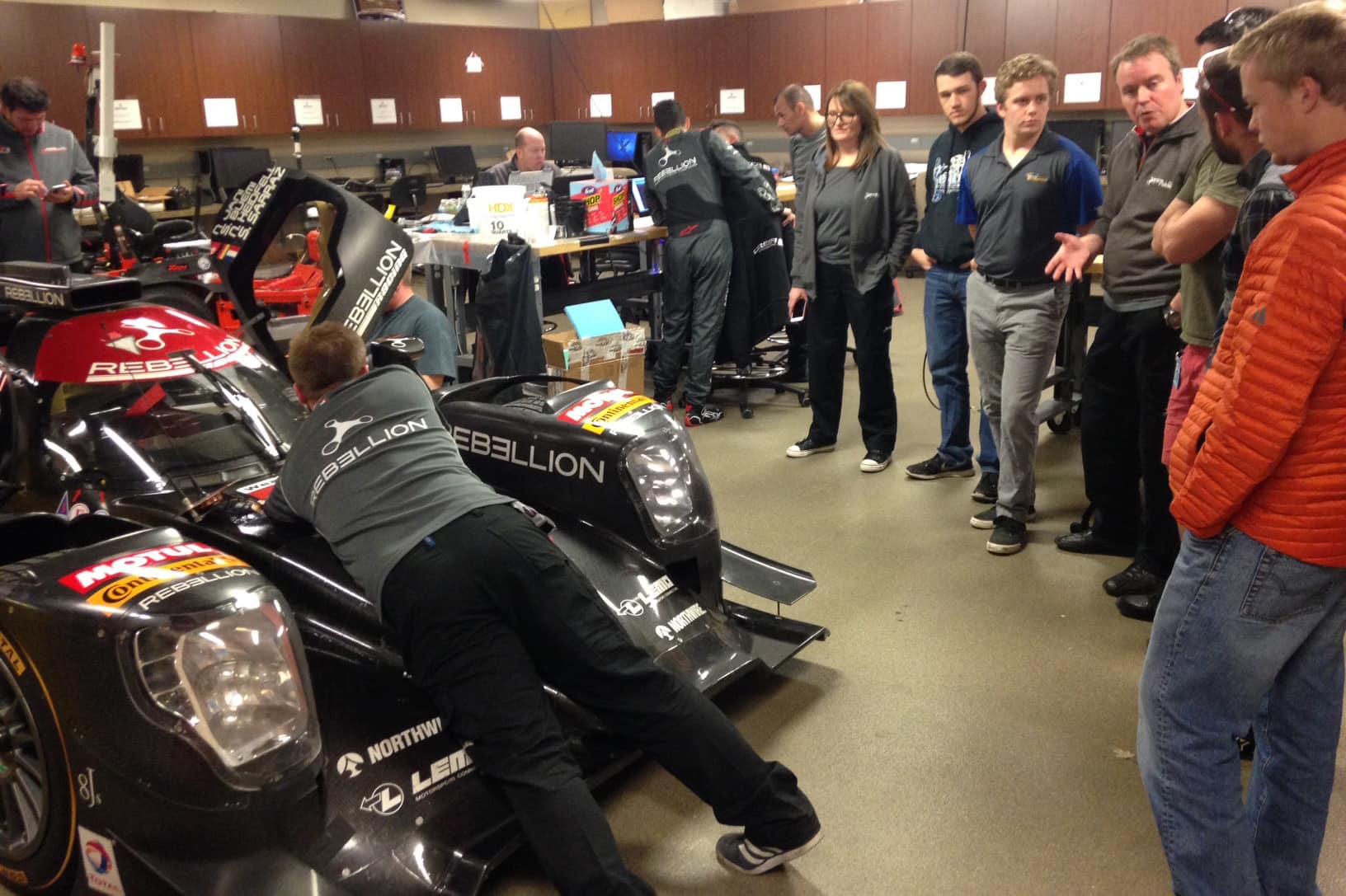 Students and staff examine a car in the Center for Motorsports Engineering