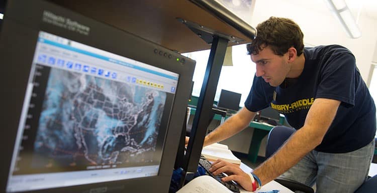 Students looks at weather on a computer screen in the Weather Center