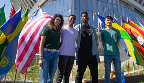 A group of students in front of international flags and the student union.