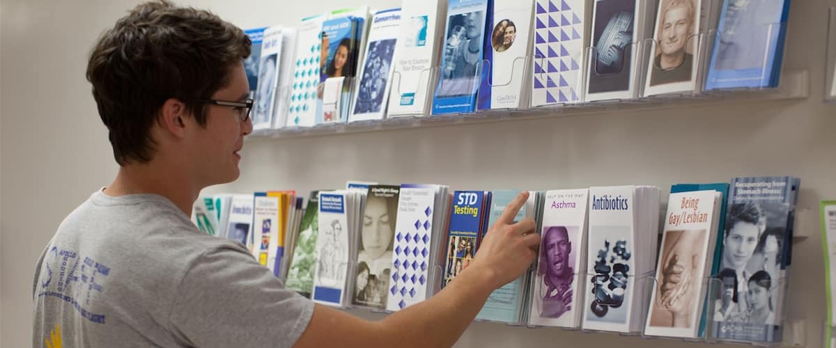 Male student looks at health brochures.