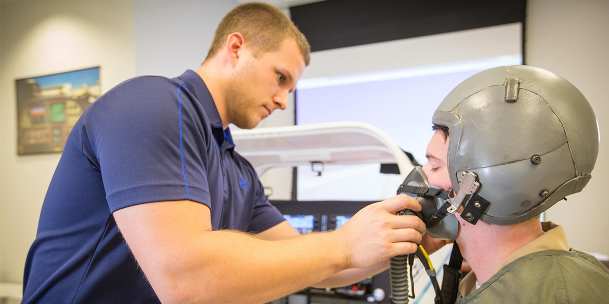 Human Factors students experiment with a fighter pilot's helmet in the Aerospace Physiology Lab.