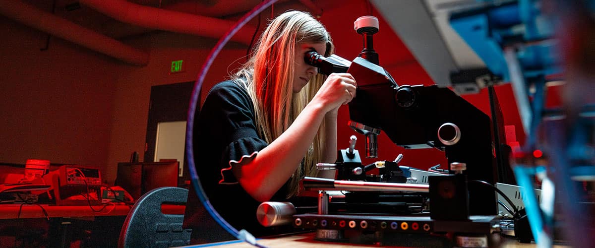 A student looks through a microscope