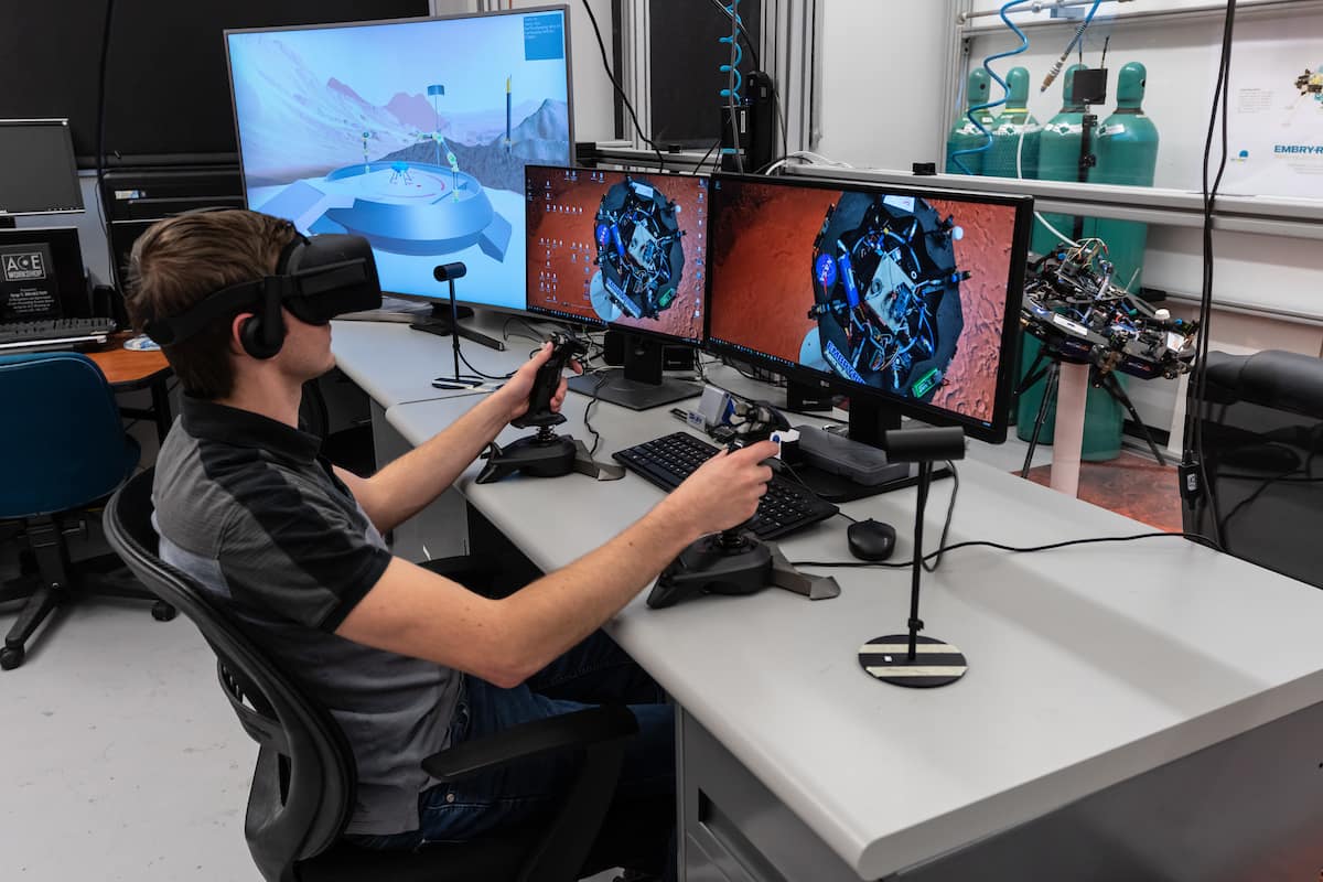 Aerospace Engineering seniors Francisco Pastrana and Patrick Serafin pictured with an autonomous spacecraft that a team of students designed and built in the Engineering Physics Propulsion Lab (EPPL) in the College of Arts and Sciences. New virtual reality software designed in the lab was also recently added along with equipment