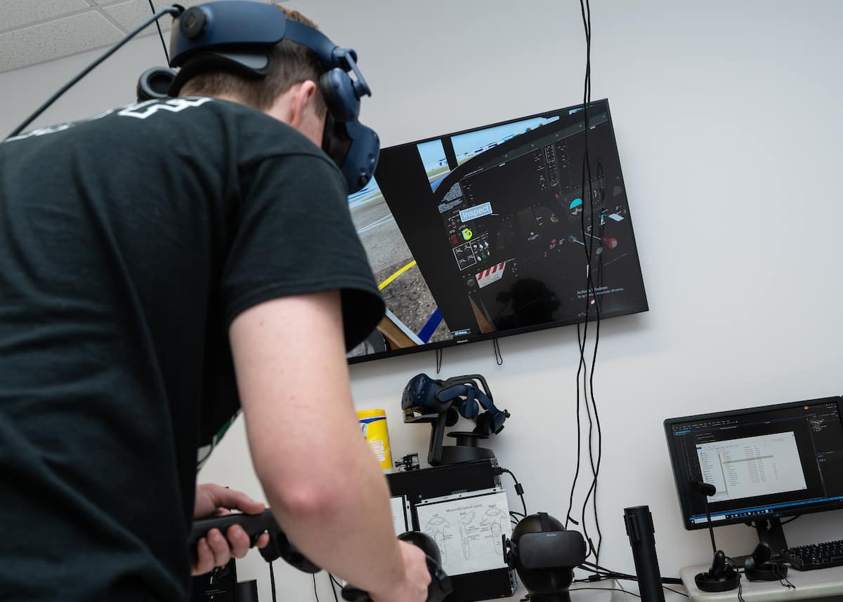A student participates in the College of Aviation's VR lab using a virtual reality checklist to preflight a Cessna 172.