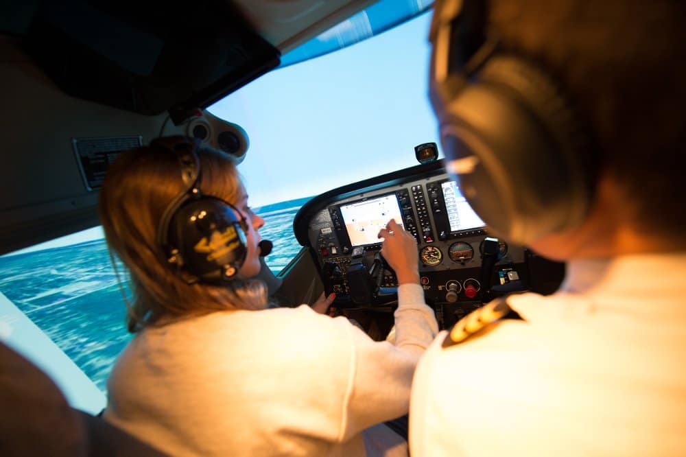 Students look at the instrument panel in a flight simulator