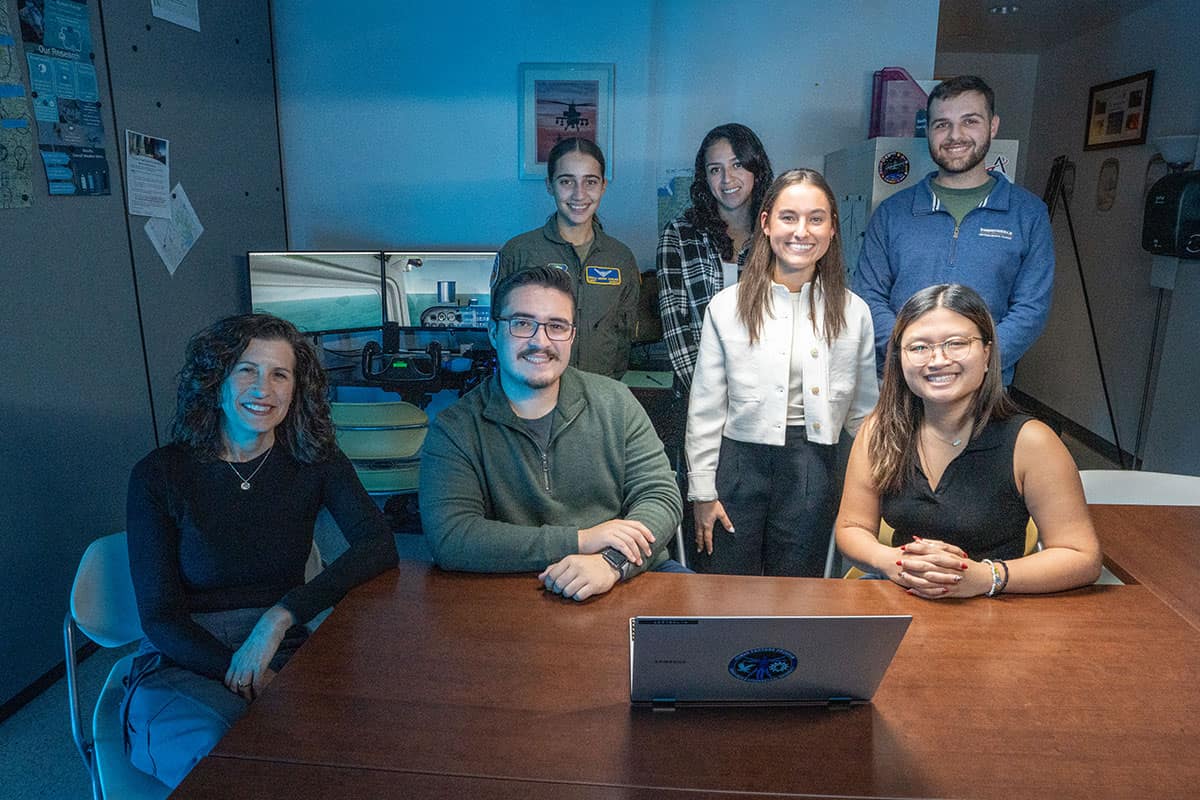 Dr. Blickensderfer poses with students in the Applied Cognition and Training Science Lab