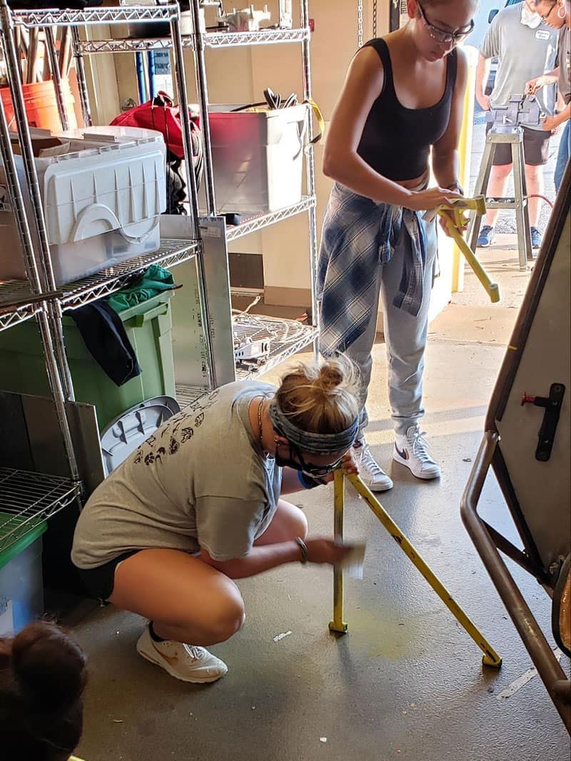 Students work on sanding down A-arms for repainting of the show car