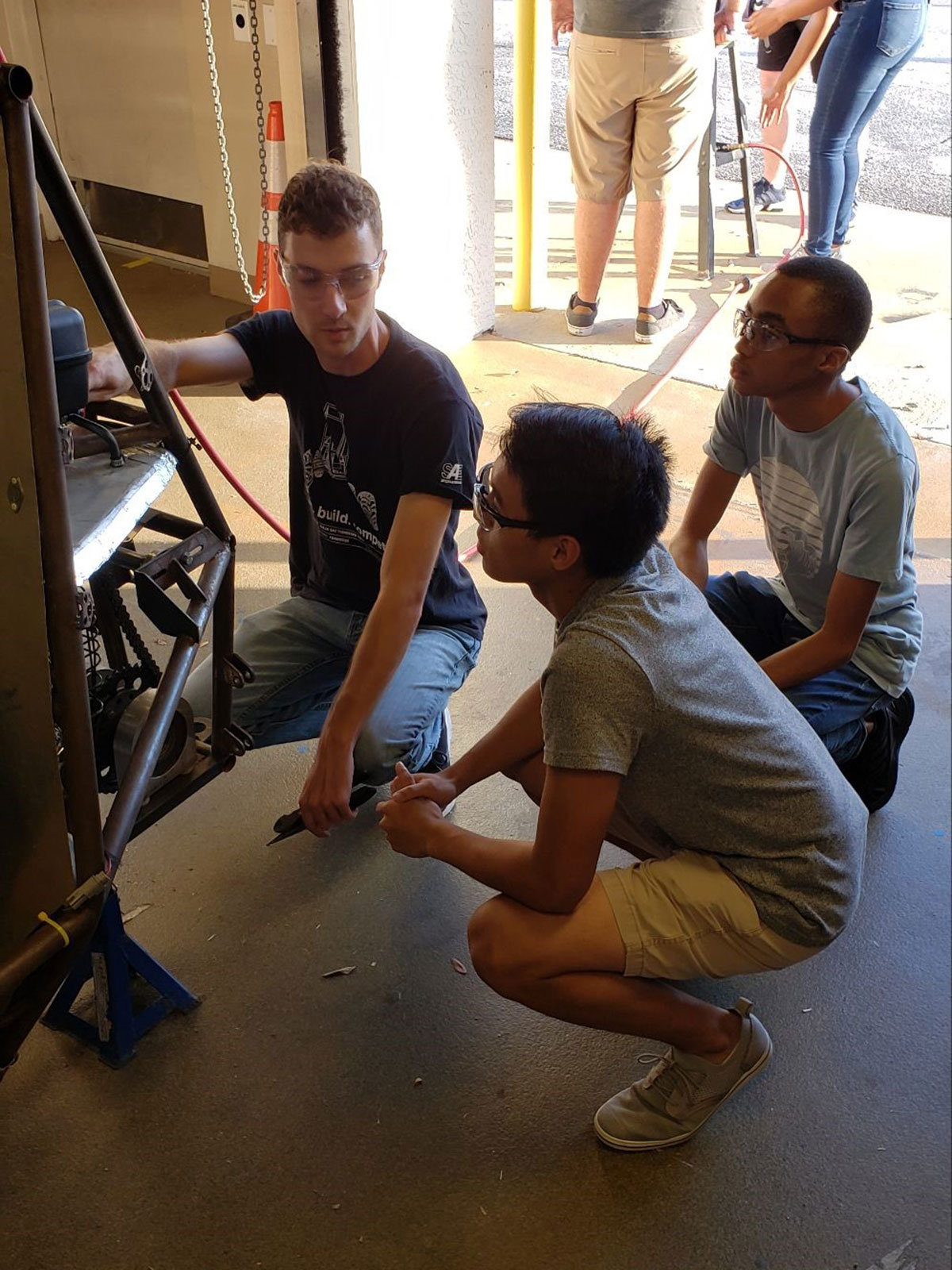 Student Justin McAuliffe explains the powertrain and drivetrain components to new team members
