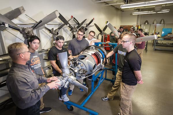Professor talks to students around engine in the Basic Engine and Propeller Systems Lab