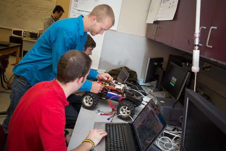 Students work on a remote-control car at the ECSSE Capstone Design Laboratory