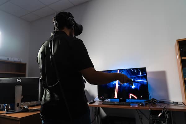 Student with VR headset plays Beatsaber