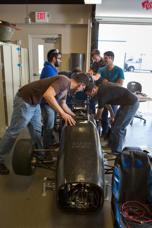Stuedents work on a car in the High Performance Vehicle Laboratory