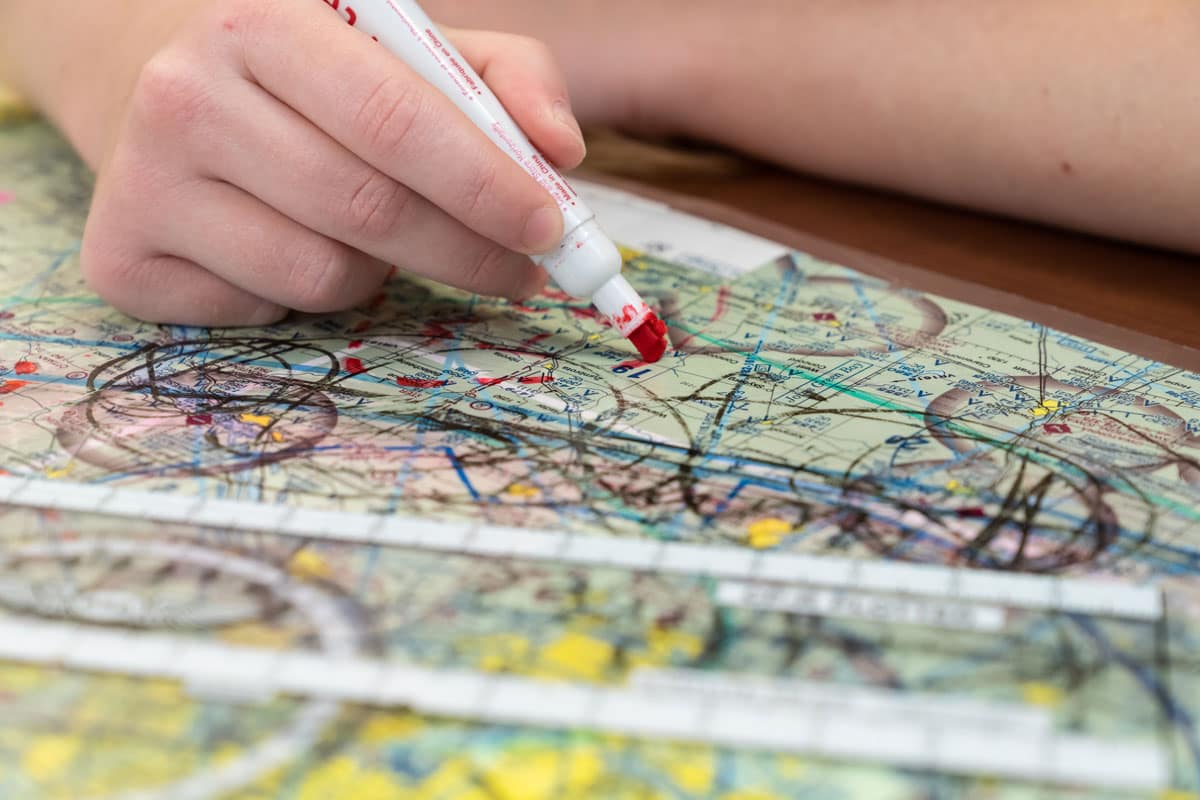 Student draws on a map.