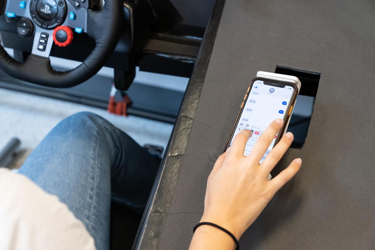Student uses cell phone during driving simulation.