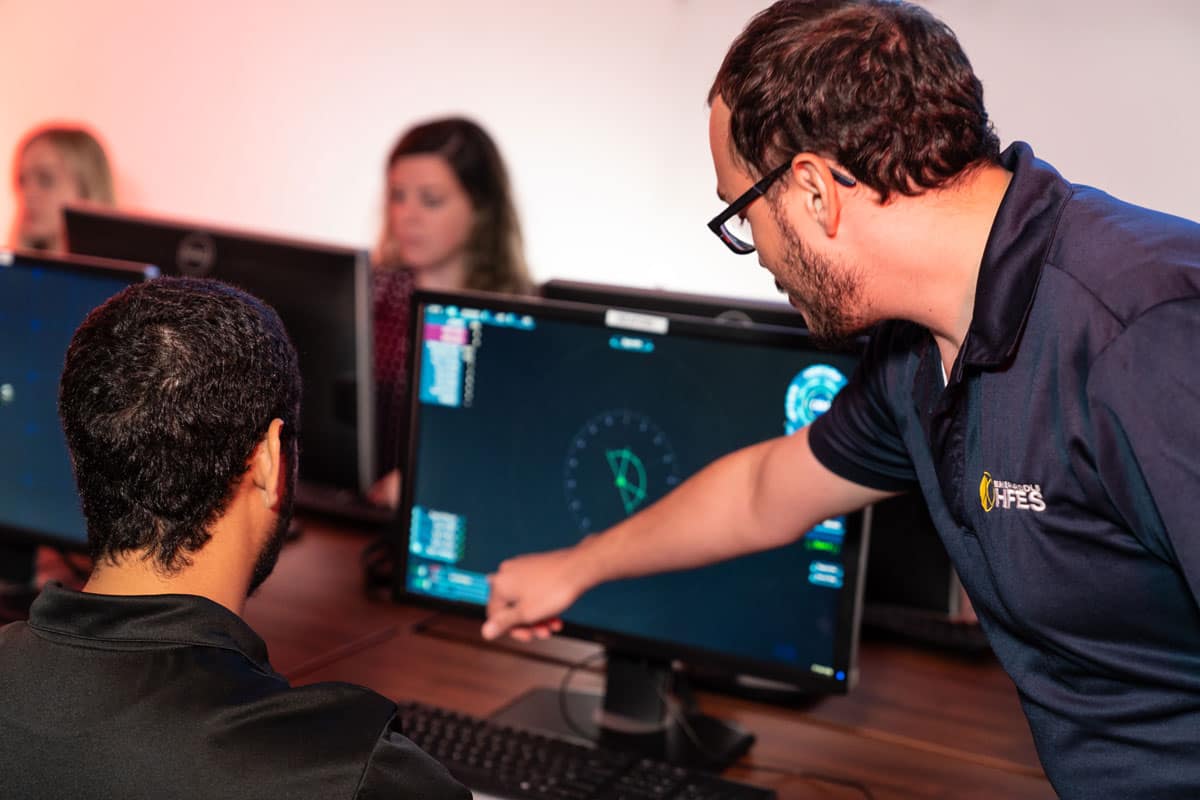 Student and faculty member look at graphs on a screen.
