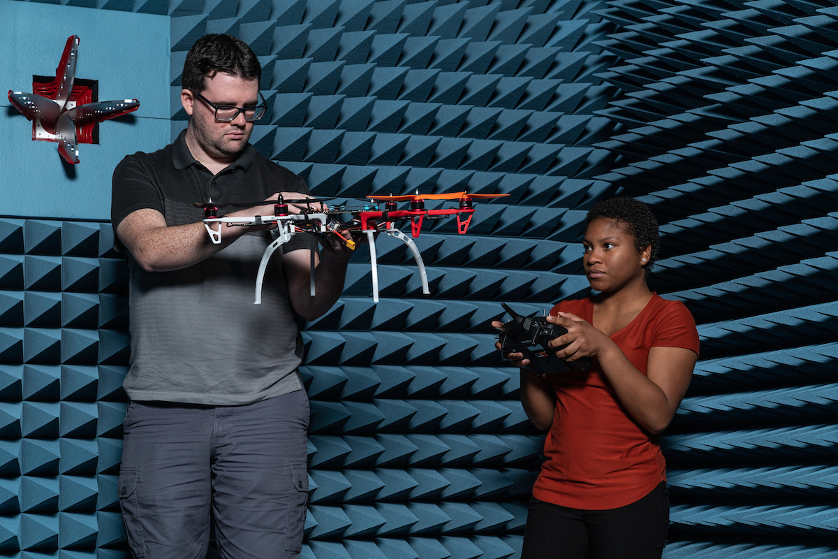 Two students work with drones.