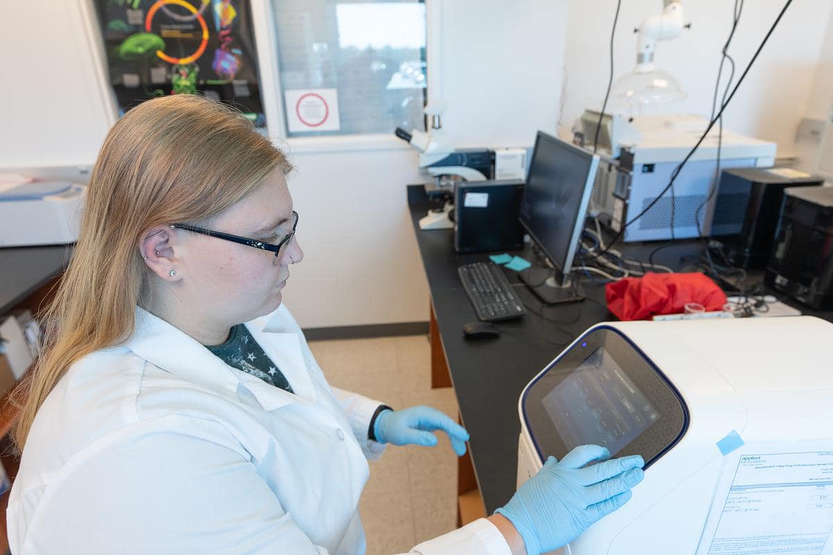 Embry-Riddle student Janelle Hicks puts samples into a real-time thermo cycler in the Space Microbiology lab.