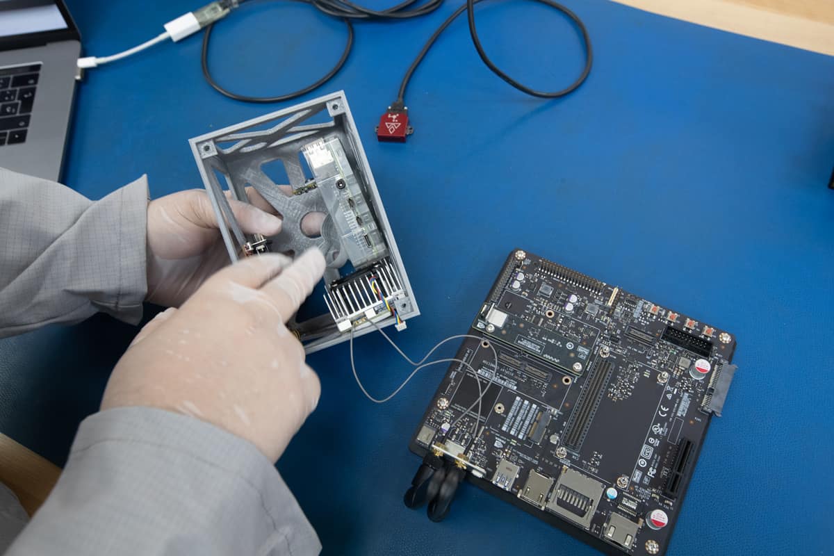 A student examines an inertial measurement unit in the class 10,000 clean room.