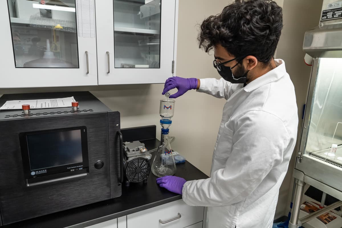 Atharv Dangore prepares a water solution in a vacuum filtration setup in preparation for FTIR spectrometry. Dangore is an Aerospace Engineering undergraduate student conducting research in the Sustainability and Environmental Engineering Laboratory (SEEL).