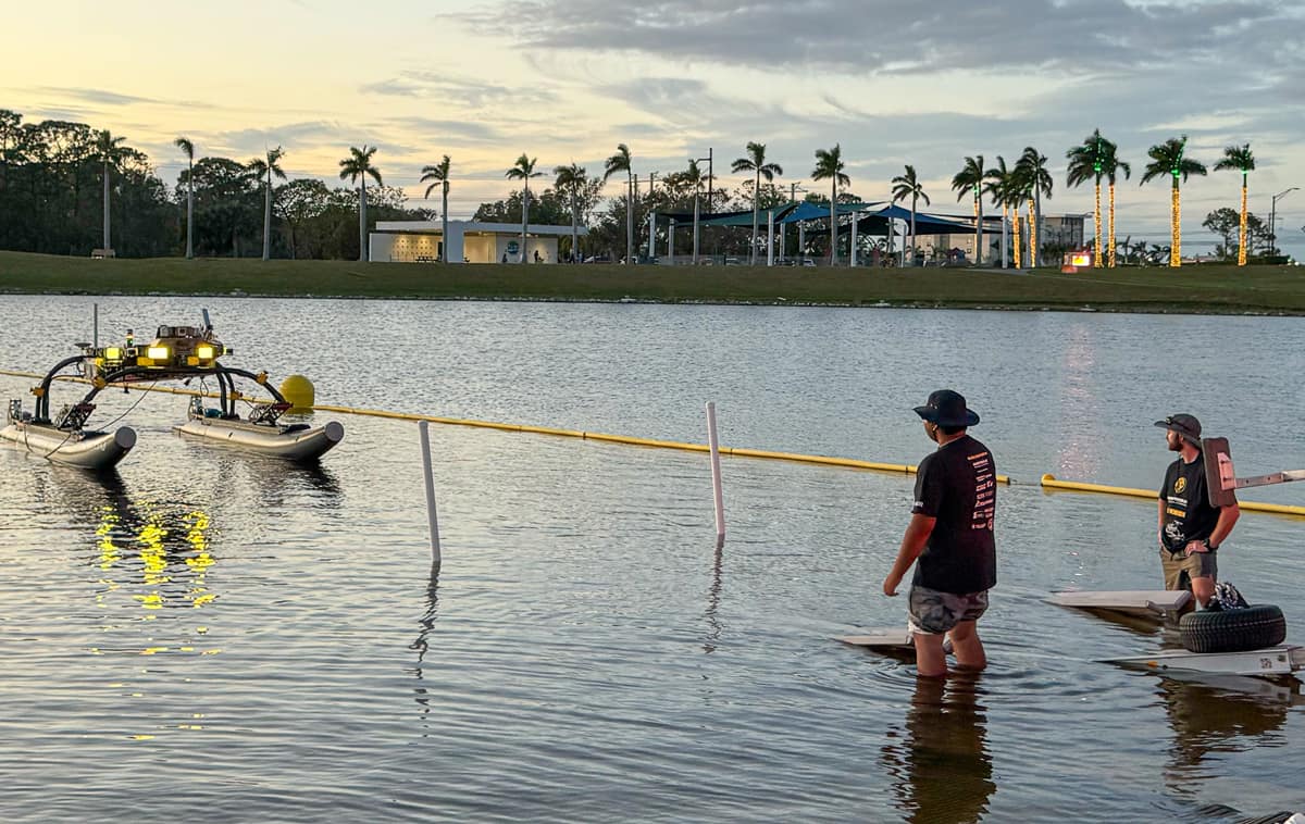 Embry-Riddle students Sarthak Aggarwal (left) and Erik Liebergall observe the operation of their robotic water vehicle at the 2024 Maritime RobotX Challenge in Sarasota, Florida.