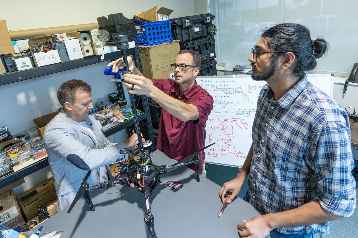 Dr. Kevin Adkins, associate professor of Aeronautical Science; Dr. Marc Compere, associate professor of Mechanical Engineering; and Ph.D. student Avinash Muthu Krishnan tweak uncrewed aircraft hardware in the Drone Lab at Embry-Riddle’s MicaPlex.
