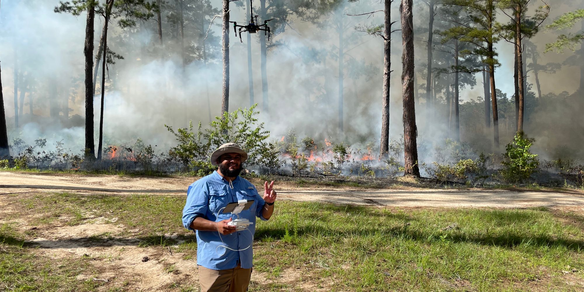 UAS major Jose Cabrera ('22, '24) stands before a prescribed fire during his time researching atmospheric data using drone technology. (Photo: Jose Cabrera)